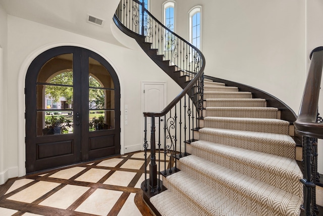 entryway with french doors and a towering ceiling