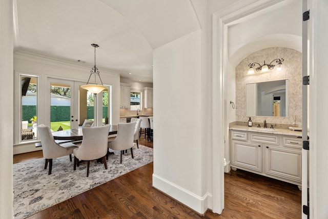 dining space with ornamental molding, dark hardwood / wood-style floors, french doors, and sink