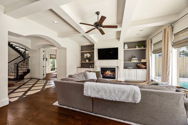 living room featuring a wealth of natural light, coffered ceiling, dark hardwood / wood-style floors, and built in shelves