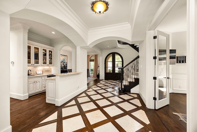 foyer featuring ornamental molding, dark hardwood / wood-style flooring, and sink