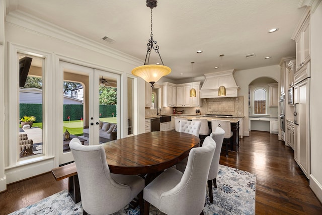 dining space featuring french doors, ornamental molding, and dark hardwood / wood-style flooring