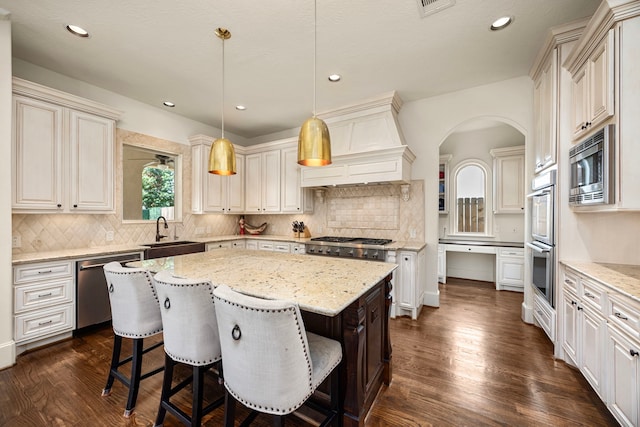 kitchen with stainless steel appliances, dark hardwood / wood-style floors, a kitchen island, and custom exhaust hood