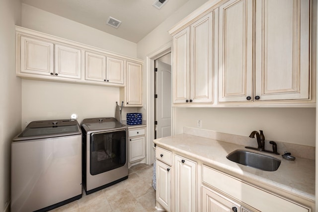 laundry area with cabinets, separate washer and dryer, and sink