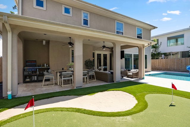 rear view of property featuring an outdoor living space, ceiling fan, a fenced in pool, and a patio area