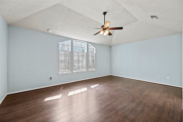 spare room featuring lofted ceiling, ceiling fan, dark wood-type flooring, and a textured ceiling