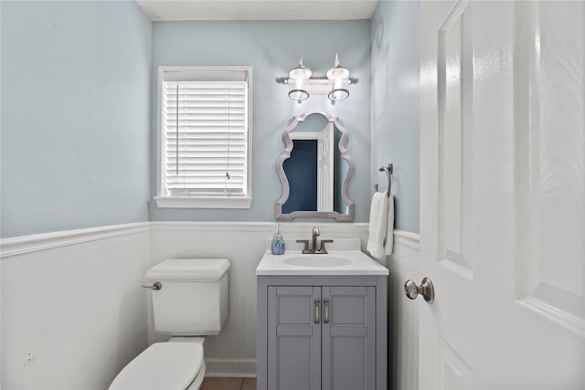 bathroom with a textured ceiling, vanity, and toilet