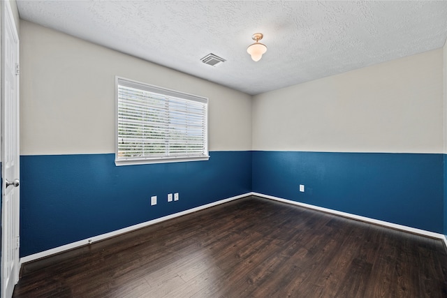 empty room featuring wood-type flooring and a textured ceiling