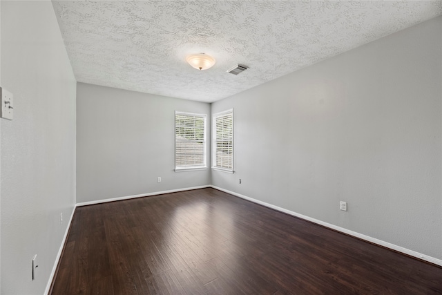 spare room featuring a textured ceiling and hardwood / wood-style flooring