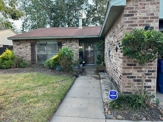 entrance to property featuring a lawn