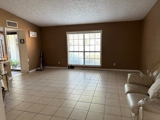 unfurnished living room featuring a textured ceiling, light tile patterned floors, and lofted ceiling