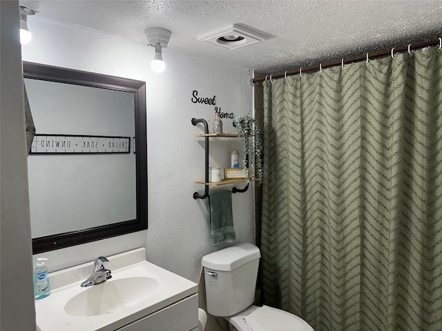 bathroom with vanity, a textured ceiling, toilet, and a shower with curtain