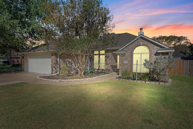 view of front of home featuring a lawn and a garage