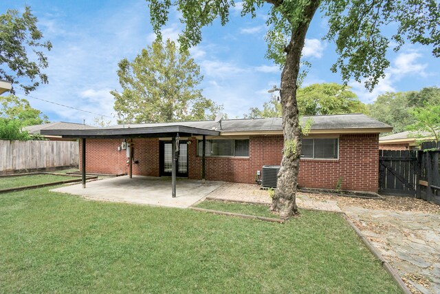 back of house featuring a lawn, cooling unit, and a patio area