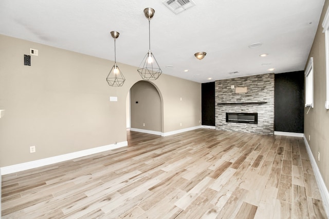 unfurnished living room featuring light wood-type flooring and a fireplace