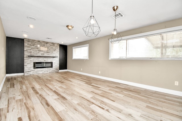 unfurnished living room with light wood-type flooring and a fireplace