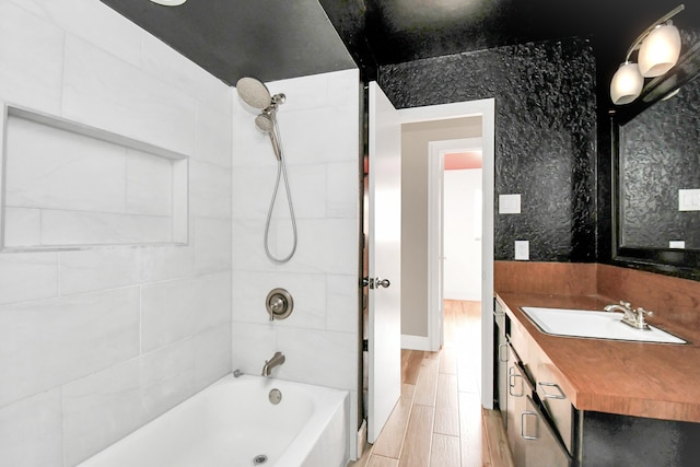 bathroom with vanity, tiled shower / bath combo, and hardwood / wood-style flooring