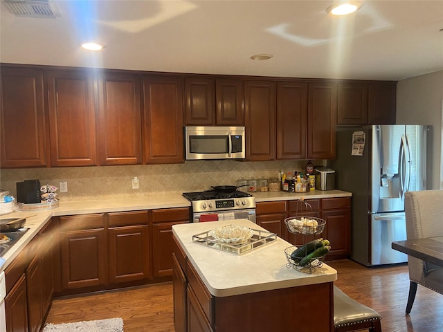 kitchen with tasteful backsplash, hardwood / wood-style floors, a center island, and stainless steel appliances