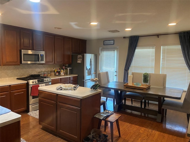 kitchen with a center island, stainless steel appliances, tasteful backsplash, and dark hardwood / wood-style floors