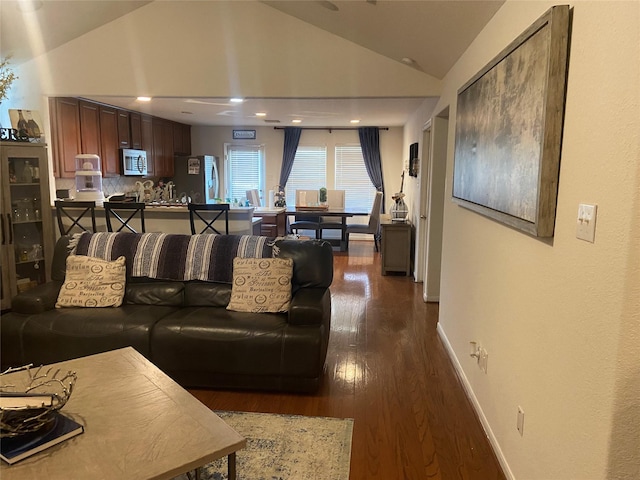 living room with dark hardwood / wood-style flooring and vaulted ceiling