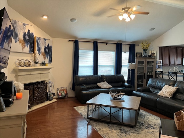 living room with ceiling fan, lofted ceiling, and dark wood-type flooring