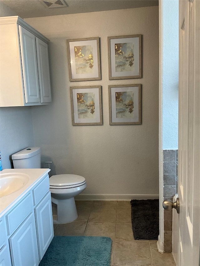 bathroom featuring tile patterned flooring, vanity, and toilet