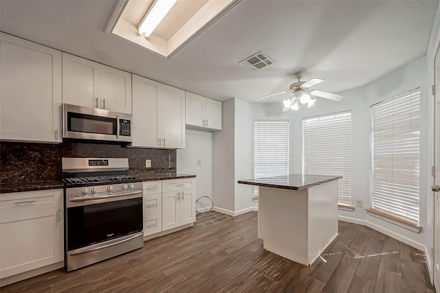 5110 Prairie Creek Dr, Houston, TX 77084 - kitchen with stainless steel appliances, backsplash, dark wood-style flooring, ceiling fan, and white cabinetry