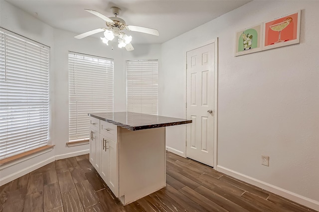 5110 Prairie Creek Dr, Houston, TX 77084 - kitchen with ceiling fan, dark wood-style floors, white cabinetry, and baseboards