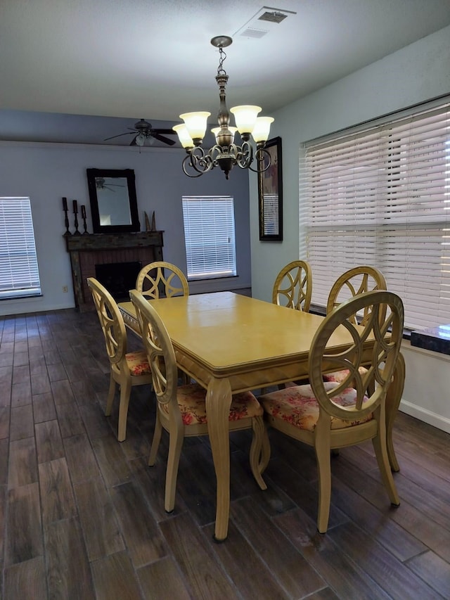 5110 Prairie Creek Dr, Houston, TX 77084 - dining room with dark wood-style flooring, a chandelier, ceiling fan, and a brick fireplace