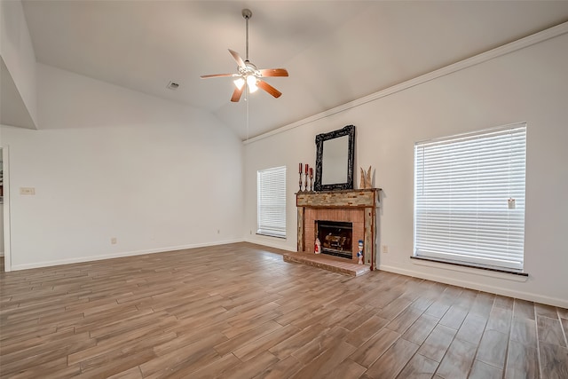 unfurnished living room with wood-type flooring, crown molding, vaulted ceiling, a fireplace, and ceiling fan