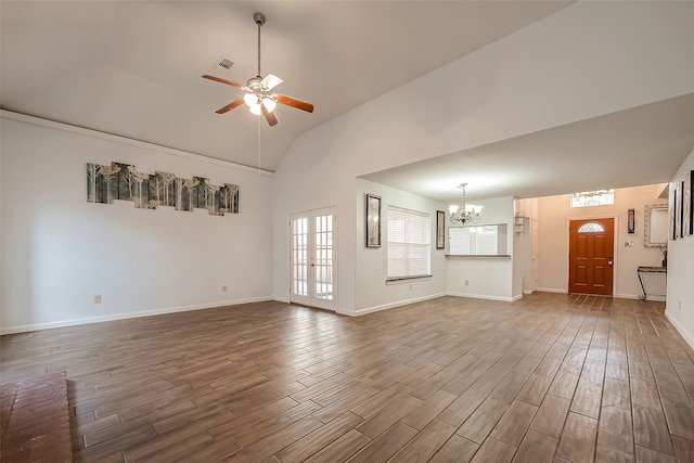 unfurnished living room with french doors, high vaulted ceiling, dark hardwood / wood-style flooring, and ceiling fan with notable chandelier