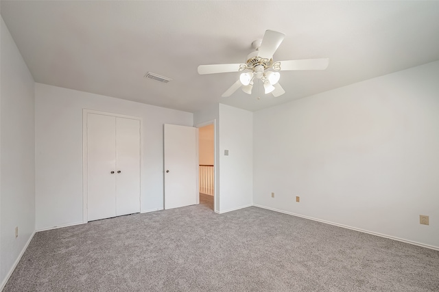 unfurnished bedroom with a closet, carpet, and ceiling fan