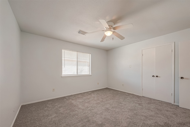 unfurnished room featuring ceiling fan and carpet