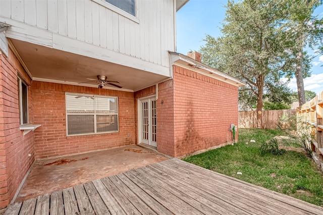 wooden deck featuring ceiling fan and a lawn