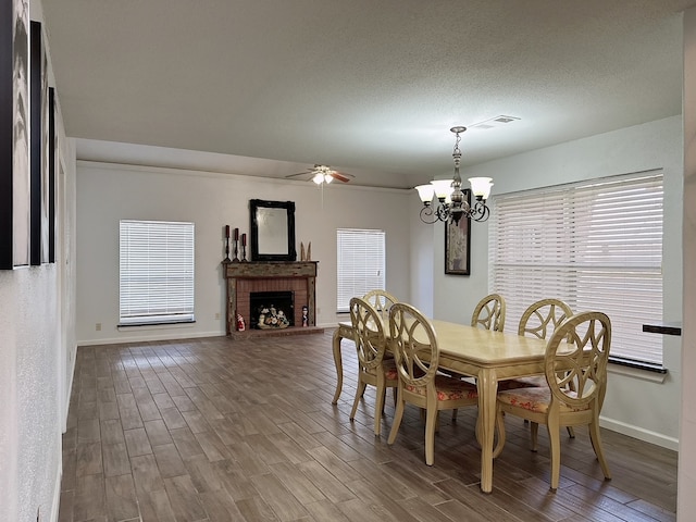 dining room featuring a wealth of natural light, a brick fireplace, and hardwood / wood-style floors