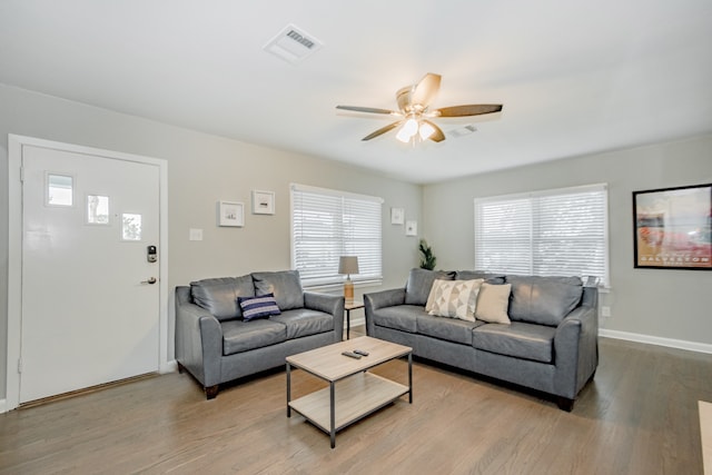 living room featuring ceiling fan, light wood-type flooring, and a healthy amount of sunlight