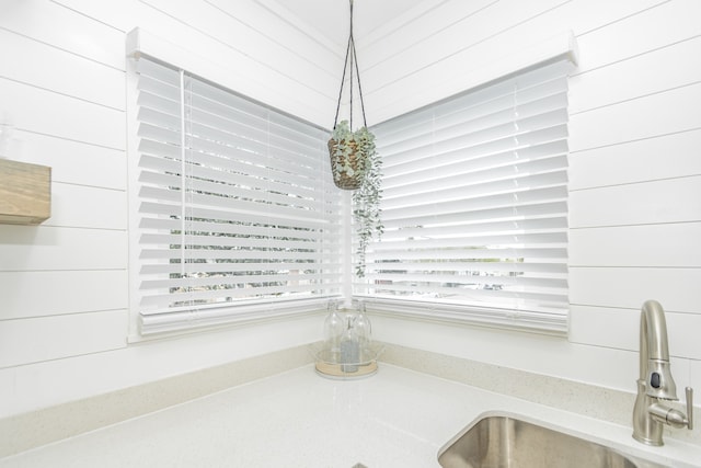 details with wood walls, sink, and pendant lighting