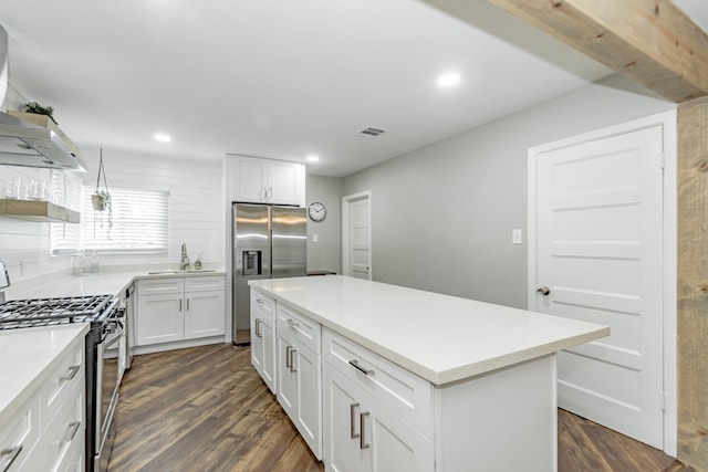 kitchen featuring white cabinetry, a center island, appliances with stainless steel finishes, and dark hardwood / wood-style flooring