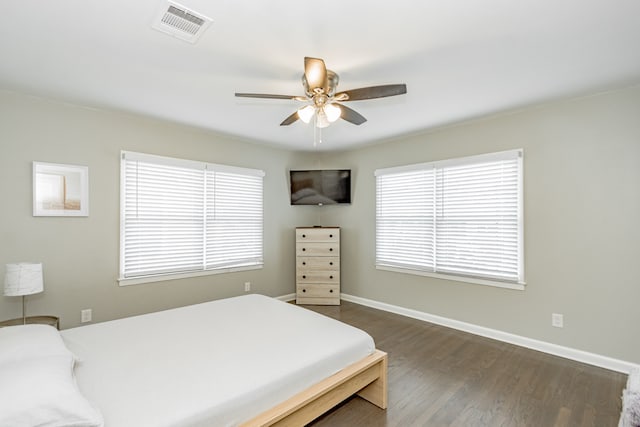 bedroom with dark hardwood / wood-style flooring and ceiling fan