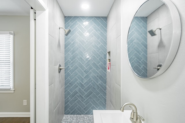 bathroom featuring a tile shower and sink