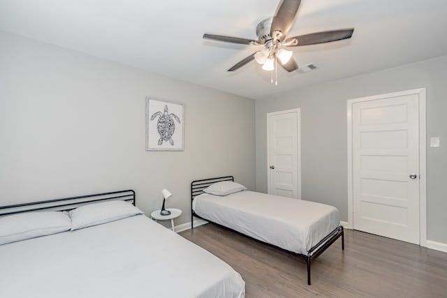 bedroom with ceiling fan and dark hardwood / wood-style flooring