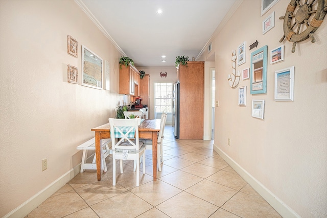 dining area featuring light tile patterned floors and ornamental molding