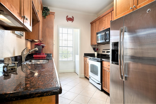 kitchen featuring light tile patterned floors, ornamental molding, sink, appliances with stainless steel finishes, and dark stone counters