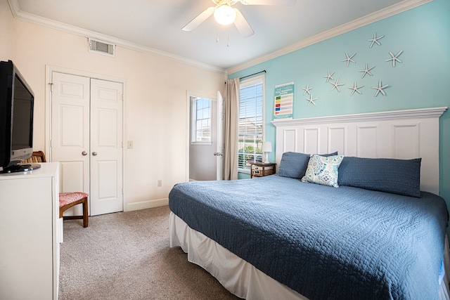 carpeted bedroom featuring ceiling fan, a closet, and crown molding