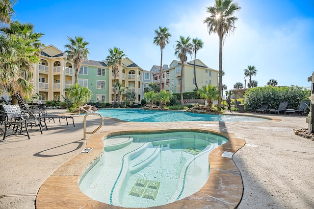 view of pool with a hot tub and a patio area