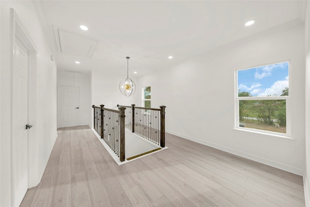 hall with ornamental molding and light hardwood / wood-style floors