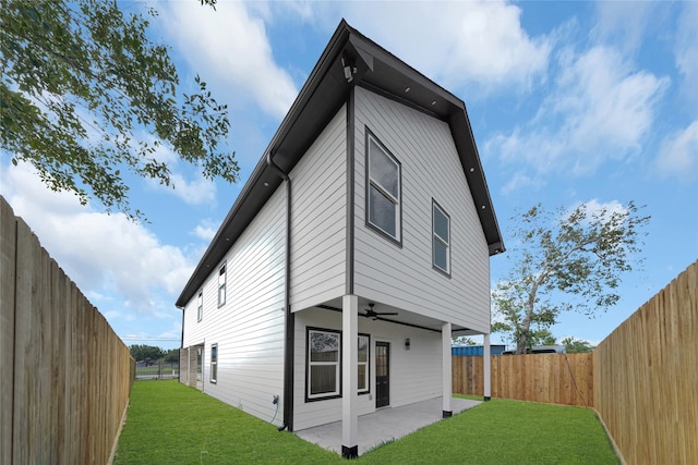 back of house featuring ceiling fan, a patio area, and a yard