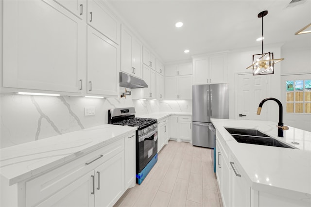 kitchen with light stone countertops, white cabinets, appliances with stainless steel finishes, and sink