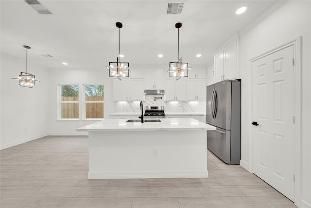 kitchen featuring pendant lighting, an island with sink, sink, white cabinetry, and appliances with stainless steel finishes