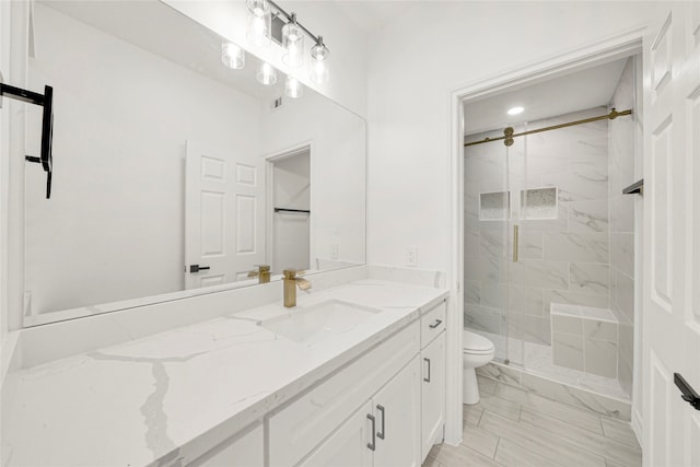 bathroom featuring vanity, toilet, and an enclosed shower