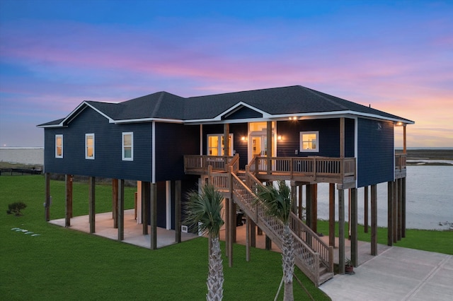 view of front facade featuring a yard, a water view, and a carport